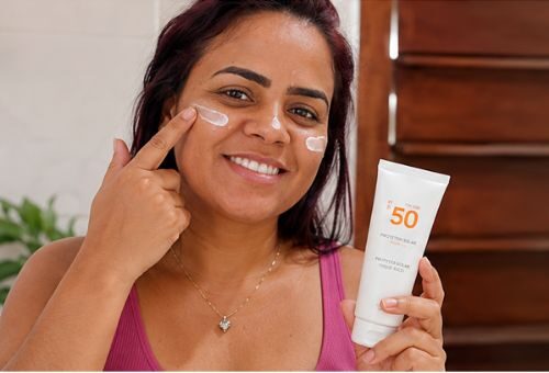 Aplicando protetor solar no rosto durante a rotina de cuidados com a pele.